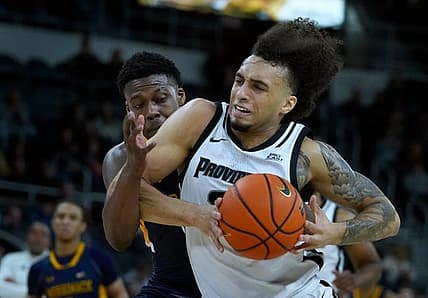 Providence Friars guard Devin Carter drives to the PC hoop  against Merrimack defender Devon Savage after scooping up a loose ball in the first half.