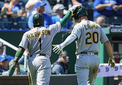 Sep 16, 2021; Kansas City, Missouri, USA; Oakland Athletics third baseman Josh Harrison (1) and left fielder Mark Canha (20) celebrate after scoring against the Kansas City Royals during the third inning at Kauffman Stadium. Mandatory Credit: Jay Biggerstaff-USA TODAY Sports