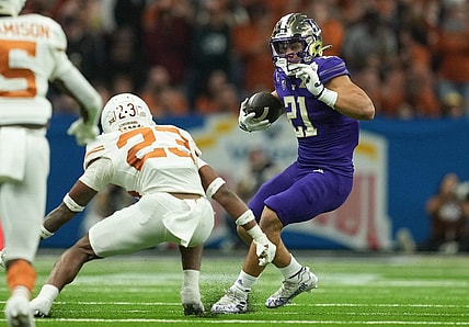 Dec 29, 2022; San Antonio, Texas, USA;  Washington Huskies running back Wayne Taulapapa (21) cuts back in front of Texas Longhorns defensive back Jahdae Barron during the first half in the 2022 Alamo Bowl at the Alamodome. Mandatory Credit: Daniel Dunn-USA TODAY Sports