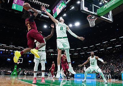 Dec 12, 2023; Boston, Massachusetts, USA; Boston Celtics center Kristaps Porzingis (8) and guard Jrue Holiday (4) defend against Cleveland Cavaliers guard Darius Garland (10) in the second quarter at TD Garden. Mandatory Credit: David Butler II-USA TODAY Sports