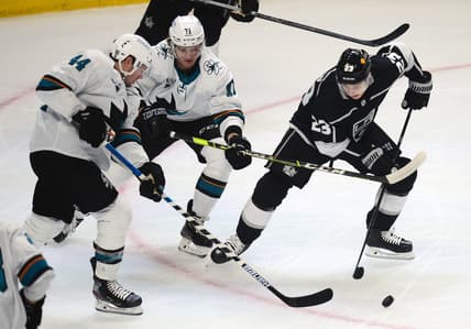 Feb 11, 2021; Los Angeles, California, USA; Los Angeles Kings right wing Dustin Brown (23) plays for the puck against San Jose Sharks defenseman Marc-Edouard Vlasic (44) and defenseman Nikolai Knyzhov (71) during the first period at Staples Center. Mandatory Credit: Gary A. Vasquez-USA TODAY Sports