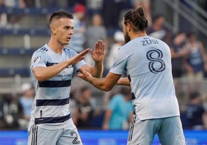 Aug 21, 2022; Kansas City, Kansas, USA; Sporting Kansas City midfielder Erik Thammy (26) celebrates with defender Graham Zusi (8) after scoring against the Portland Timbers during the first half of the match at Children's Mercy Park. Mandatory Credit: Denny Medley-USA TODAY Sports