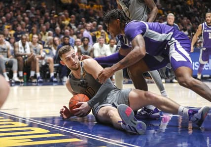 Mar 4, 2023; Morgantown, West Virginia, USA; West Virginia Mountaineers guard Erik Stevenson (10) dives for the ball while defended by Kansas State Wildcats guard Tykei Greene (4) during the first half at WVU Coliseum. Mandatory Credit: Ben Queen-USA TODAY Sports
