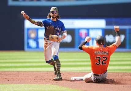 May 20, 2023; Toronto, Ontario, CAN; Toronto Blue Jays shortstop Bo Bichette (11) throws to first base after tagging out Baltimore Orioles designated hitter Ryan O'Hearn (32) at second base during the second inning at Rogers Centre. Mandatory Credit: Nick Turchiaro-USA TODAY Sports