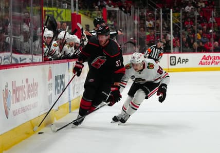 Feb 19, 2024; Raleigh, North Carolina, USA;  Carolina Hurricanes right wing Andrei Svechnikov (37) skates with the puck past Chicago Blackhawks center Philipp Kurashev (23) during the first period at PNC Arena. Mandatory Credit: James Guillory-USA TODAY Sports