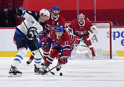 Jun 7, 2021; Montreal, Quebec, CAN; Winnipeg Jets defenseman Logan Stanley (64) plays the puck and Montreal Canadiens forward Josh Anderson (17) defends during the second period in game four of the second round of the 2021 Stanley Cup Playoffs at the Bell Centre. Mandatory Credit: Eric Bolte-USA TODAY Sports