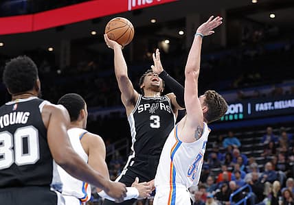 Nov 7, 2021; Oklahoma City, Oklahoma, USA; San Antonio Spurs forward Keldon Johnson (3) goes up for a basket as Oklahoma City Thunder center Mike Muscala (33) defends during the second quarter at Paycom Center. Mandatory Credit: Alonzo Adams-USA TODAY Sports