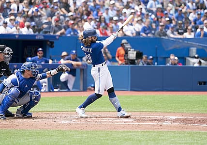 Jul 17, 2022; Toronto, Ontario, CAN; Toronto Blue Jays shortstop Bo Bichette (11) hits a sacrifice fly ball scoring a run against the Kansas City Royals during the third inning at Rogers Centre. Mandatory Credit: Nick Turchiaro-USA TODAY Sports