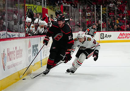 Feb 19, 2024; Raleigh, North Carolina, USA;  Carolina Hurricanes right wing Andrei Svechnikov (37) skates with the puck past Chicago Blackhawks center Philipp Kurashev (23) during the first period at PNC Arena. Mandatory Credit: James Guillory-USA TODAY Sports