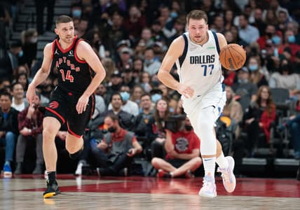 Oct 23, 2021; Toronto, Ontario, CAN; Dallas Mavericks guard Luka Doncic (77) dribbles the ball up court as Toronto Raptors guard Svi Mykhailiuk (14) gives chase during the second quarter at Scotiabank Arena. Mandatory Credit: Nick Turchiaro-USA TODAY Sports
