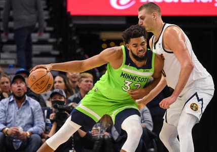 Oct 30, 2021; Minneapolis, Minnesota, USA;  Minnesota Timberwolves center Karl-Anthony Towns (32) is called for an offensive foul against Denver Nuggets center Nikola Jokic (15) during the second quarter at Target Center. Mandatory Credit: Nick Wosika-USA TODAY Sports