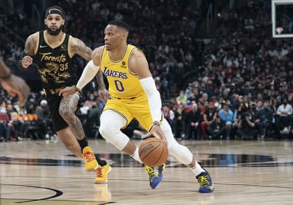 Mar 18, 2022; Toronto, Ontario, CAN; Los Angeles Lakers guard Russell Westbrook (0) controls the ball as Toronto Raptors guard Gary Trent Jr. (33) tries to defend during the first quarter at Scotiabank Arena. Mandatory Credit: Nick Turchiaro-USA TODAY Sports