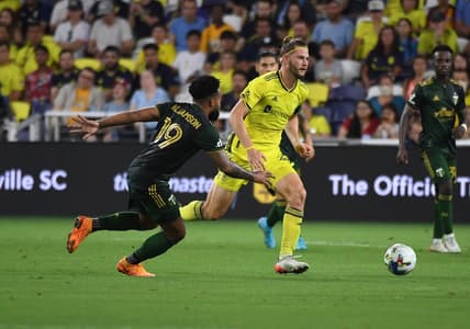Jul 3, 2022; Nashville, Tennessee, USA; Nashville SC defender Walker Zimmerman (25) plays the ball against Portland Timbers midfielder Eryk Williamson (19) during the second half at Geodis Park. Mandatory Credit: Christopher Hanewinckel-USA TODAY Sports