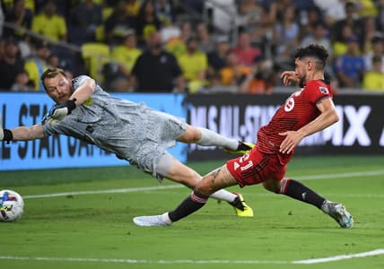 Aug 6, 2022; Nashville, Tennessee, USA; Toronto FC midfielder Jonathan Osorio (21) scores against Nashville SC goalkeeper Joe Willis (1) for his second goal of the first half at Geodis Park. Mandatory Credit: Christopher Hanewinckel-USA TODAY Sports