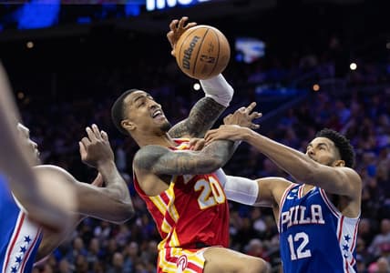 Nov 28, 2022; Philadelphia, Pennsylvania, USA; Atlanta Hawks forward John Collins (20) is fouled while driving for a shot between Philadelphia 76ers forward Tobias Harris (12) and center Joel Embiid (21) during the second quarter at Wells Fargo Center. Mandatory Credit: Bill Streicher-USA TODAY Sports