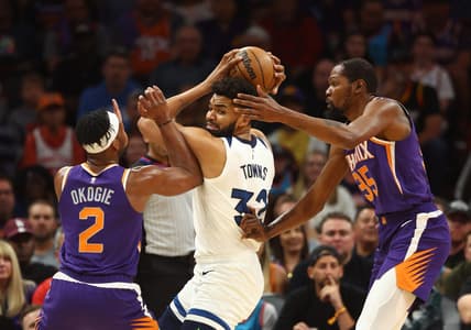 Mar 29, 2023; Phoenix, Arizona, USA; Minnesota Timberwolves center Karl-Anthony Towns (32) controls the ball against Phoenix Suns forward Josh Okogie (2) and Kevin Durant (35) in the first half at Footprint Center. Mandatory Credit: Mark J. Rebilas-USA TODAY Sports