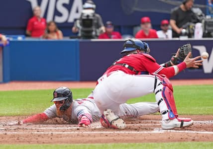 Jul 1, 2023; Toronto, Ontario, CAN; Boston Red Sox first baseman Justin Turner (2) slides into home plate scoring a run ahead of the tag from Toronto Blue Jays catcher Danny Jansen (9) during the fifth inning at Rogers Centre. Mandatory Credit: Nick Turchiaro-USA TODAY Sports