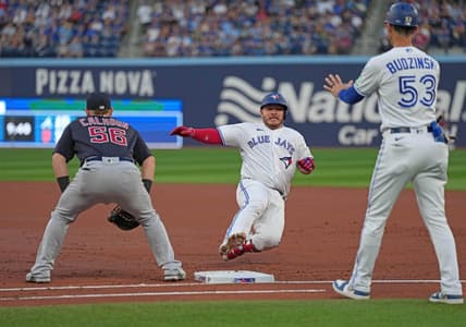 Aug 25, 2023; Toronto, Ontario, CAN; Toronto Blue Jays catcher Alejandro Kirk (30) slides back into first bases after hitting a single against the Cleveland Guardians during the second inning at Rogers Centre. Mandatory Credit: Nick Turchiaro-USA TODAY Sports