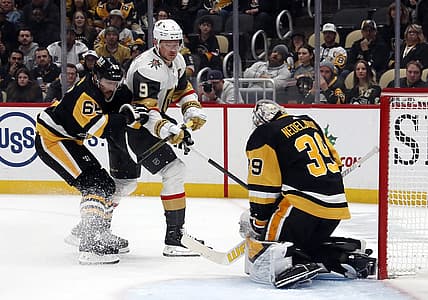 Nov 19, 2023; Pittsburgh, Pennsylvania, USA;  Pittsburgh Penguins goaltender Alex Nedeljkovic (39) makes a save against Vegas Golden Knights center Jack Eichel (9) as Pens defenseman Erik Karlsson (65) defends during the second period at PPG Paints Arena. Pittsburgh won 3-0. Mandatory Credit: Charles LeClaire-USA TODAY Sports