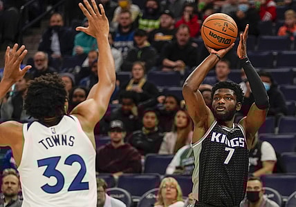 Nov 17, 2021; Minneapolis, Minnesota, USA;  Sacramento Kings forward Chimezie Metu (7) shoots a three-pointer as Minnesota Timberwolves center Karl-Anthony Towns (32) defends during the first quarter at Target Center. Mandatory Credit: Nick Wosika-USA TODAY Sports