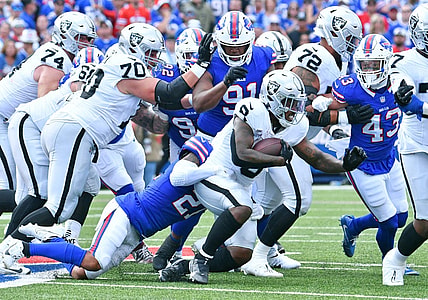 Sep 17, 2023; Orchard Park, New York, USA; Las Vegas Raiders running back Josh Jacobs (8) is tackled by Buffalo Bills safety Jordan Poyer (21) in the second quarter at Highmark Stadium. Mandatory Credit: Mark Konezny-USA TODAY Sports