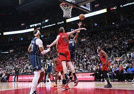 Feb 28, 2024; Toronto, Ontario, CAN; Dallas Mavericks guard Kyrie Irving (11) drives to the basket as Toronto Raptors center Jakob Poeltl (19) tries to defend during the second quarter at Scotiabank Arena. Mandatory Credit: Nick Turchiaro-USA TODAY Sports