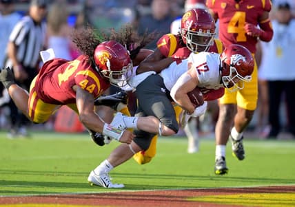 Oct 8, 2022; Los Angeles, California, USA;  Washington State Cougars wide receiver Robert Ferrel (12) drags USC Trojans linebacker Tuasivi Nomura (44) and defensive back Calen Bullock (7) into the end zone for a touchdown in the first half at United Airlines Field at Los Angeles Memorial Coliseum. Mandatory Credit: Jayne Kamin-Oncea-USA TODAY Sports