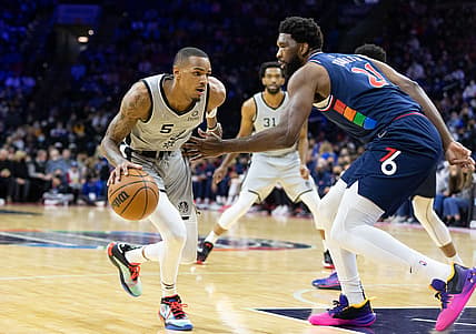 Jan 7, 2022; Philadelphia, Pennsylvania, USA; San Antonio Spurs guard Dejounte Murray (5) dribbles the ball against Philadelphia 76ers center Joel Embiid (21) during the first quarter at Wells Fargo Center. Mandatory Credit: Bill Streicher-USA TODAY Sports
