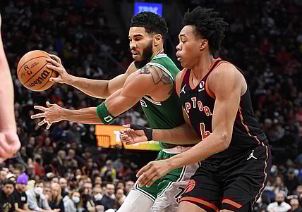 Nov 28, 2021; Toronto, Ontario, CAN;  Boston Celtics forward Jayson Tatum (0) passes the ball away from Toronto Raptors forward Scottie Barnes (4) in the second half at Scotiabank Arena. Mandatory Credit: Dan Hamilton-USA TODAY Sports
