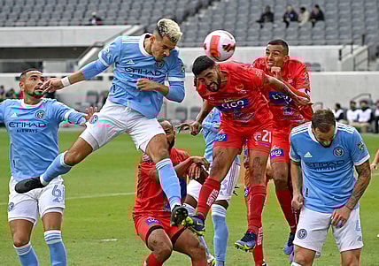 Feb 23, 2022; Los Angeles, CA, USA; New York City midfielder Alfredo Morales (7) heads the ball for a goal past Santos de Guapiles defender Everardo Rubio (21)during the first half of the game at Banc of California Stadium. Mandatory Credit: Jayne Kamin-Oncea-USA TODAY Sports