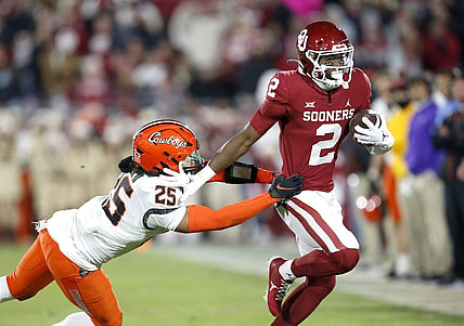 Nov 19, 2022; Norman, Oklahoma, USA;  Oklahoma Sooners running back Jovantae Barnes (2) runs the ball against Oklahoma State Cowboys safety Jason Taylor II (25)  in the second quarter at Gaylord Family-Oklahoma Memorial Stadium. Mandatory Credit: Sarah Phipps-USA TODAY Sports