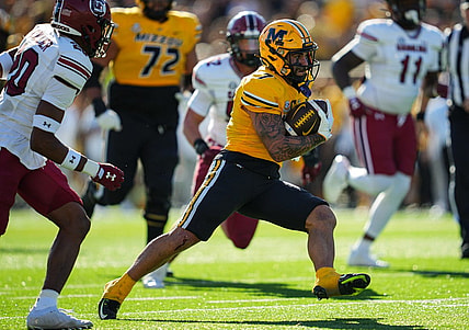 Oct 21, 2023; Columbia, Missouri, USA; Missouri Tigers running back Cody Schrader (7) runs the ball against South Carolina Gamecocks defensive back Judge Collier (20) during the first half at Faurot Field at Memorial Stadium. Mandatory Credit: Jay Biggerstaff-USA TODAY Sports
