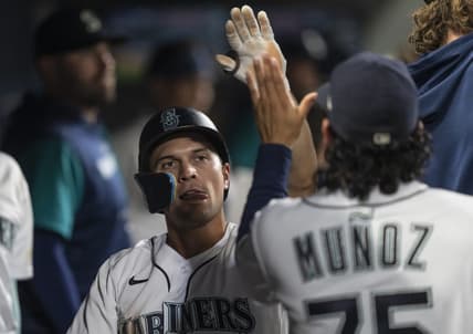 Sep 10, 2022; Seattle, Washington, USA; Seattle Mariners second baseman Adam Frazier (26) is congrulated by teammates in the dugout after scoring a run during the seventh inning against the Atlanta Braves at T-Mobile Park. Mandatory Credit: Stephen Brashear-USA TODAY Sports