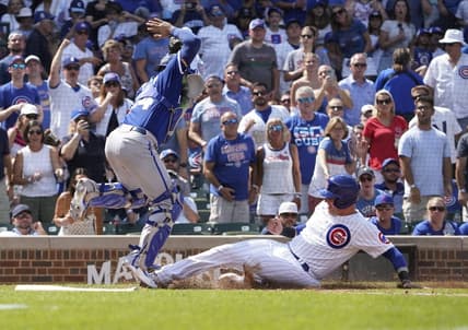 Aug 19, 2023; Chicago, Illinois, USA; Chicago Cubs catcher Yan Gomes (15) is safe at home plate as Kansas City Royals catcher Freddy Fermin (34) takes the throw during the fourth inning at Wrigley Field. Mandatory Credit: David Banks-USA TODAY Sports
