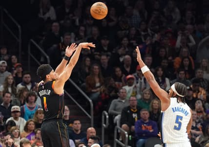 Dec 31, 2023; Phoenix, Arizona, USA; Phoenix Suns guard Devin Booker (1) shoots over Orlando Magic forward Paolo Banchero (5) during the second half at Footprint Center. Mandatory Credit: Joe Camporeale-USA TODAY Sports