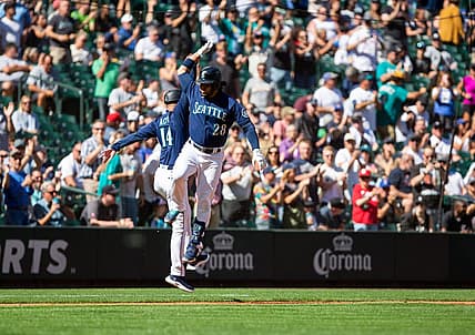 Sep 7, 2022; Seattle, Washington, USA;  Seattle Mariners third baseman Eugenio Suarez (28) celebrates with third base coach Manny Acta (14) after hitting a two run home run for his 1,000th career hit, against the Chicago White Sox during the third inning at T-Mobile Park. Mandatory Credit: Lindsey Wasson-USA TODAY Sports