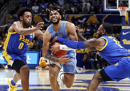 Dec 30, 2022; Pittsburgh, Pennsylvania, USA; North Carolina Tar Heels guard R.J. Davis (middle) drives to the basket between Pittsburgh Panthers guard Nelly Cummings (0) and guard Jamarius Burton (11) during the first half at Petersen Events Center. Mandatory Credit: Charles LeClaire-USA TODAY Sports
