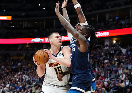 Feb 7, 2023; Denver, Colorado, USA; Minnesota Timberwolves forward Taurean Prince (12) and center Naz Reid (11) defend on Denver Nuggets center Nikola Jokic (15) in the second quarter at Ball Arena. Mandatory Credit: Ron Chenoy-USA TODAY Sports