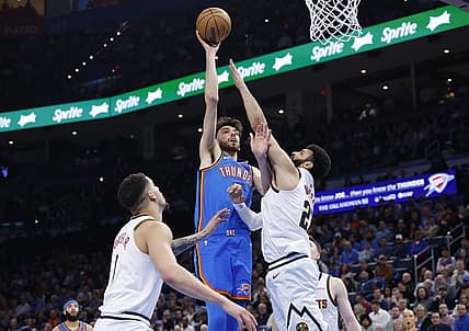 Jan 31, 2024; Oklahoma City, Oklahoma, USA; Oklahoma City Thunder forward Chet Holmgren (7) shoots as Denver Nuggets guard Jamal Murray (27) defends during the second half at Paycom Center. Mandatory Credit: Alonzo Adams-USA TODAY Sports