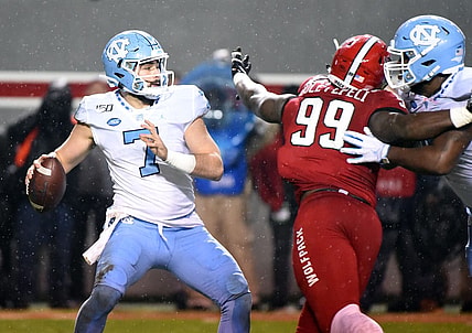 Nov 30, 2019; Raleigh, NC, USA; North Carolina Tar Heels quarterback Sam Howell (7) drops back to pass as North Carolina State Wolfpack defensive end Joseph Boletepeli (99) rushes during the first half at Carter-Finley Stadium. Mandatory Credit: Rob Kinnan-USA TODAY Sports