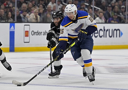 Mar 26, 2023; Los Angeles, California, USA;   St. Louis Blues center Jordan Kyrou (25) and Los Angeles Kings left wing Alex Iafallo (19) battle for the puck in the third period at Crypto.com Arena. Mandatory Credit: Jayne Kamin-Oncea-USA TODAY Sports