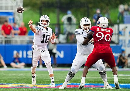 Sep 23, 2023; Lawrence, Kansas, USA; Brigham Young Cougars quarterback Kedon Slovis (10) throws a pass as Kansas Jayhawks defensive lineman Jereme Robinson (90) defends during the second half at David Booth Kansas Memorial Stadium. Mandatory Credit: Jay Biggerstaff-USA TODAY Sports