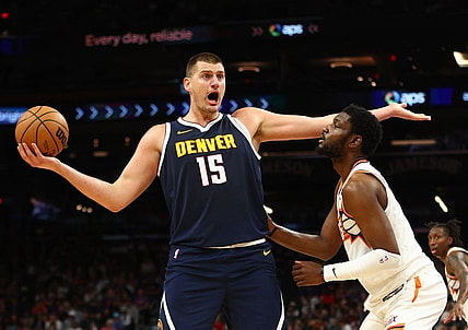 Oct 10, 2023; Phoenix, Arizona, USA; Denver Nuggets center Nikola Jokic (15) against Phoenix Suns forward Chimezie Metu (4) during a preseason game at Footprint Center. Mandatory Credit: Mark J. Rebilas-USA TODAY Sports