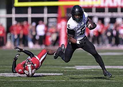 Nov 18, 2023; Bloomington, Indiana, USA;  Michigan State Spartans running back Nathan Carter (5) evades tackle by Indiana Hoosiers defensive back Phillip Dunnam (6) during the first quarter at Memorial Stadium. Mandatory Credit: Marc Lebryk-USA TODAY Sports