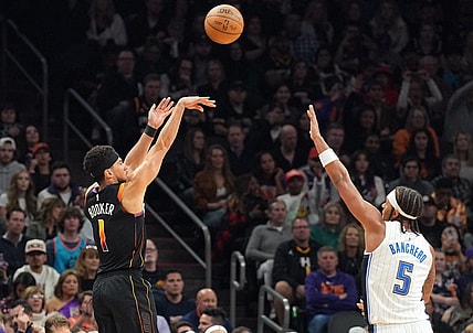 Dec 31, 2023; Phoenix, Arizona, USA; Phoenix Suns guard Devin Booker (1) shoots over Orlando Magic forward Paolo Banchero (5) during the second half at Footprint Center. Mandatory Credit: Joe Camporeale-USA TODAY Sports
