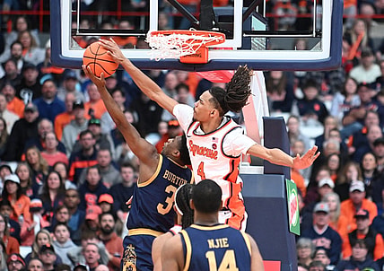 Feb 24, 2024; Syracuse, New York, USA; Syracuse Orange forward Chris Bell (4) blocks a shot by Notre Dame Fighting Irish guard Markus Burton (3) in the second half at the JMA Wireless Dome. Mandatory Credit: Mark Konezny-USA TODAY Sports