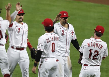 Apr 5, 2021; Cincinnati, Ohio, USA; Cincinnati Reds left fielder Nick Castellanos (2) and shortstop  Eugenio Suarez (7) react with left fielder Tyler Naquin (12) and infielder Alex Blandino (0) after the Reds defeated the Pittsburgh Pirates at Great American Ball Park. Mandatory Credit: David Kohl-USA TODAY Sports