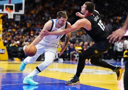 Nov 3, 2023; Denver, Colorado, USA; Denver Nuggets center Nikola Jokic (15) fouls Dallas Mavericks guard Luka Doncic (77) in the third quarter at Ball Arena. Mandatory Credit: Ron Chenoy-USA TODAY Sports