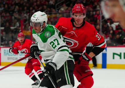 Feb 24, 2024; Raleigh, North Carolina, USA;  Dallas Stars left wing Mason Marchment (27) checks Carolina Hurricanes right wing Andrei Svechnikov (37) during the first period at PNC Arena. Mandatory Credit: James Guillory-USA TODAY Sports