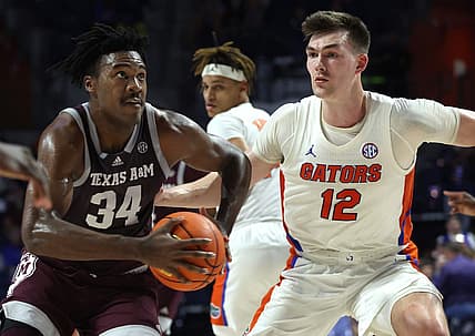 Jan 4, 2023; Gainesville, Florida, USA; Texas A&M Aggies forward Julius Marble (34) drives to the basket as Florida Gators forward Colin Castleton (12) defends during the first half at Exactech Arena at the Stephen C. O'Connell Center. Mandatory Credit: Kim Klement-USA TODAY Sports